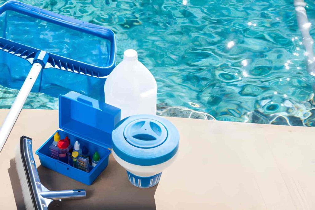 Pool cleaning and maintenance service Jensen Beach tools including skimmer net, chlorine dispenser, and chemical kit by poolside
