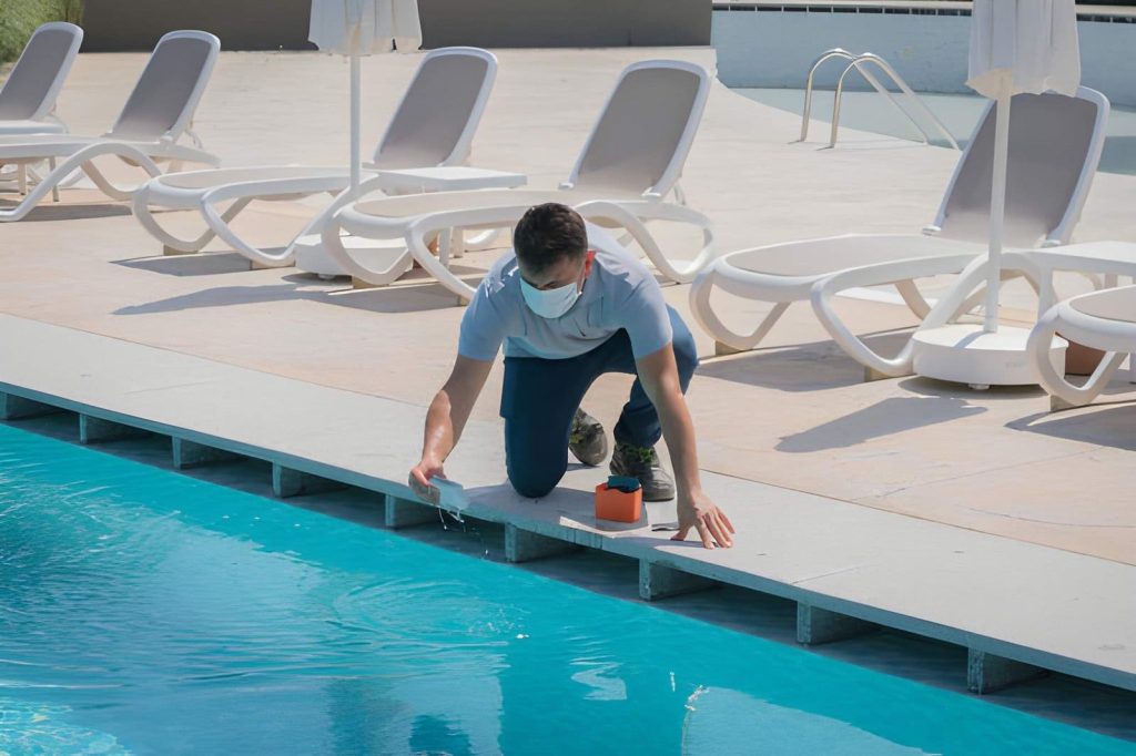 Pool maintenance Port St Lucie FL professional testing pool water quality with kit near lounge chairs and umbrellas