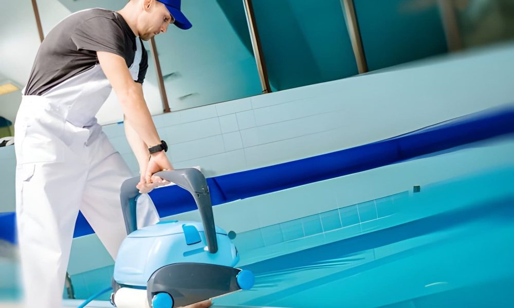 Hobe Sound Pool Service technician operating robotic pool cleaner at residential swimming pool.