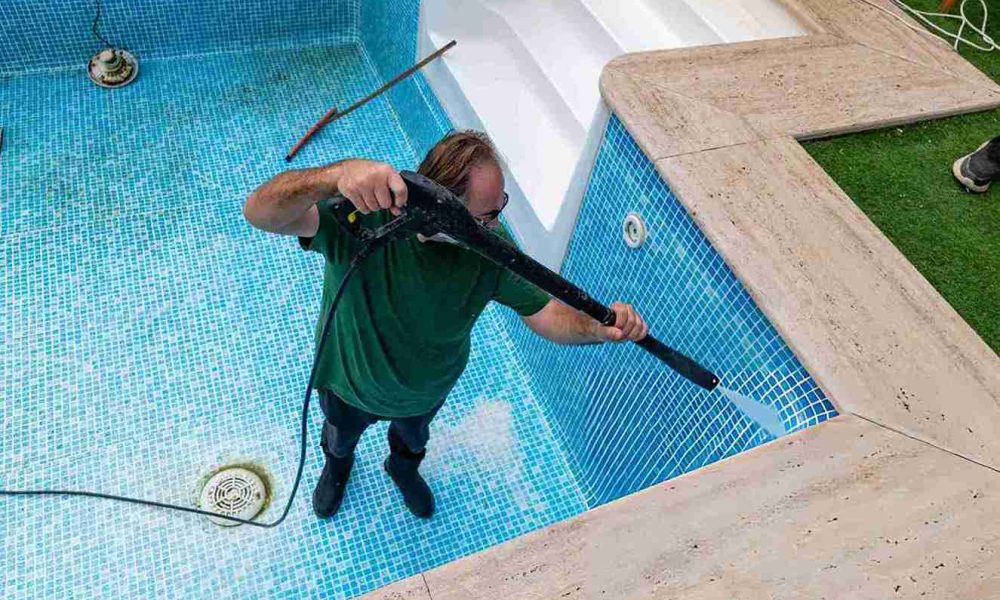 Pool cleaning service Port St Lucie professional pressure washing empty mosaic tiled swimming pool interior with drain and steps