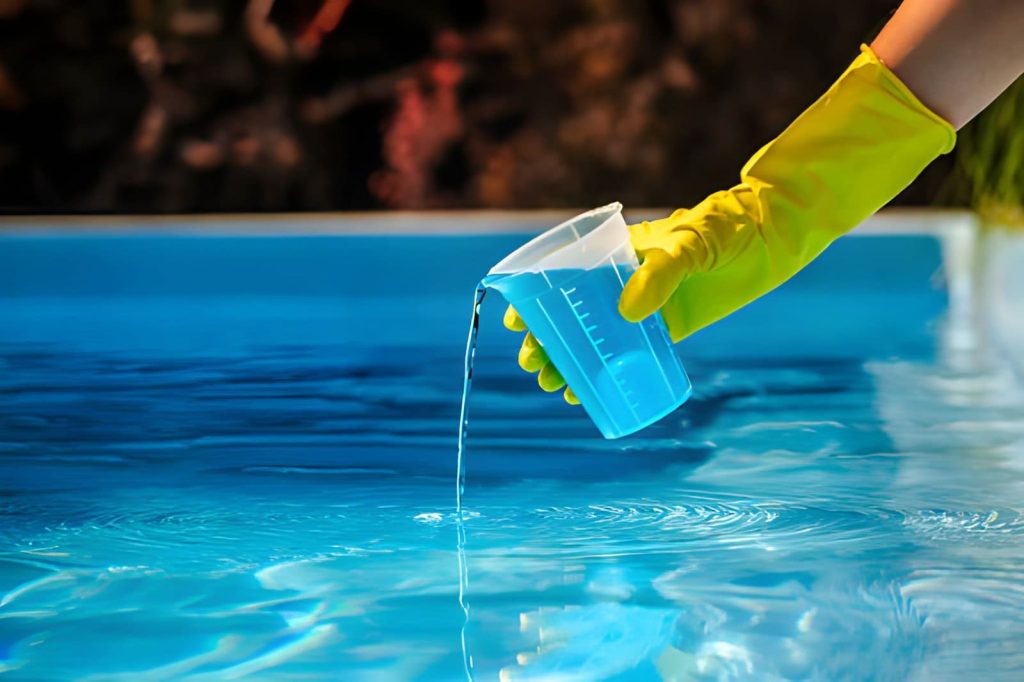 Pool cleaning and maintenance service Jensen Beach professional pouring blue liquid chemical into pool water with yellow glove
