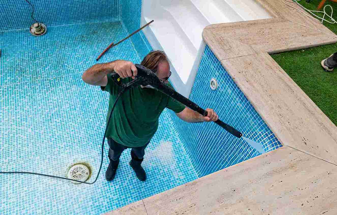 Pool cleaning service Port St Lucie professional pressure washing empty mosaic tiled swimming pool interior with drain and steps