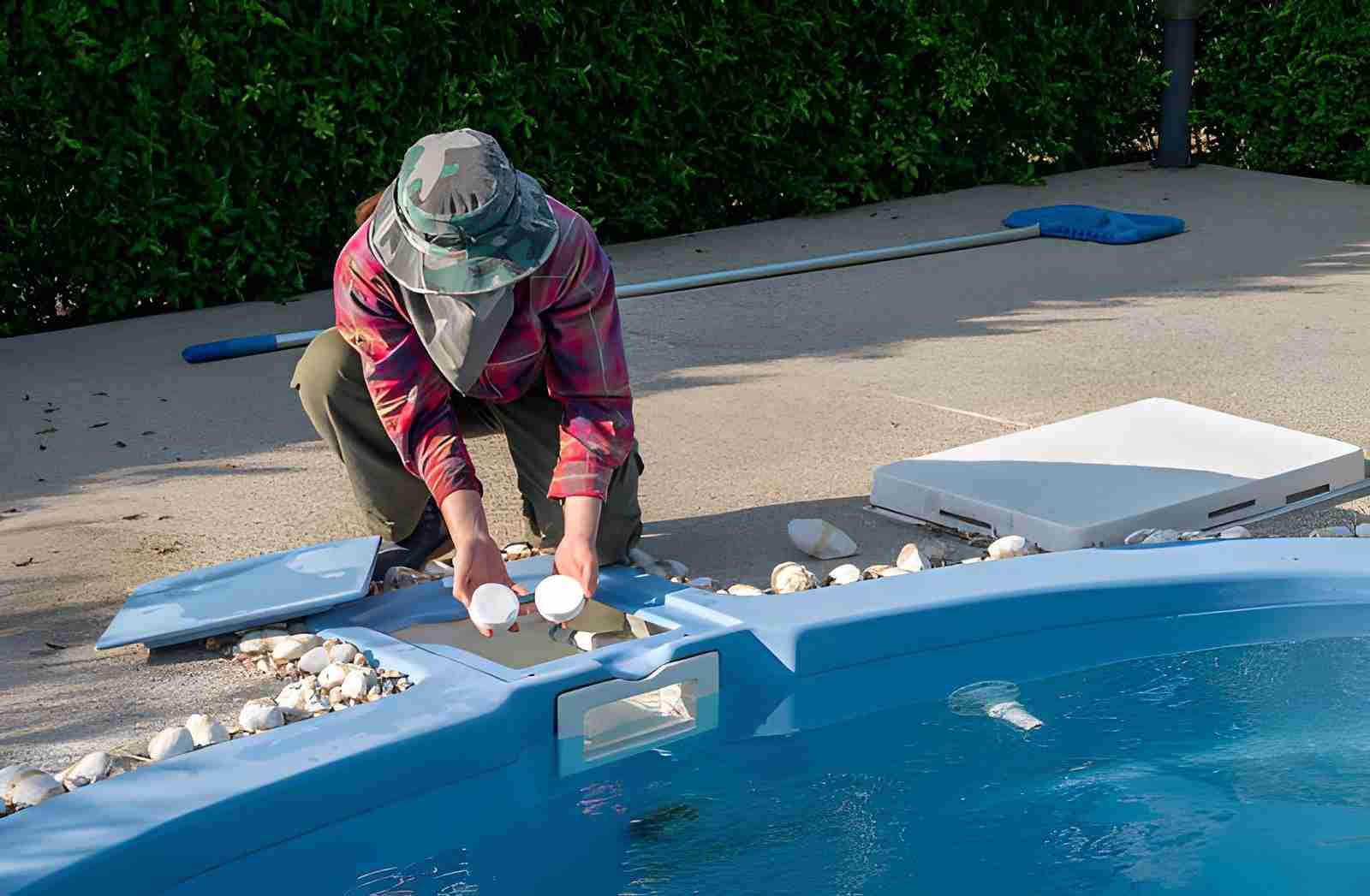 Pool cleaning service Stuart FL worker testing water quality beside residential swimming pool.